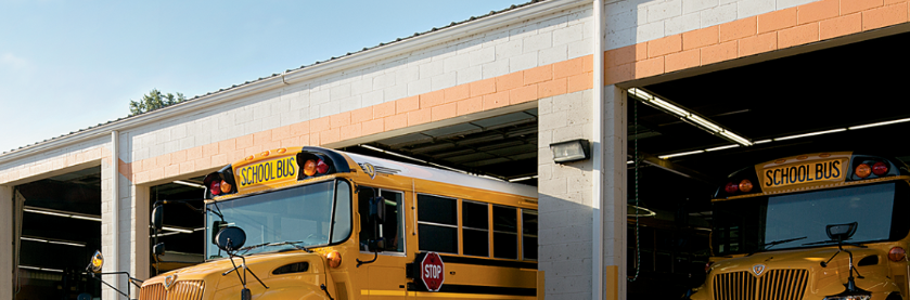Two yellow school bus parked in a garage